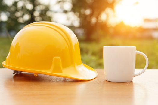 Close up coffee cup and safety helmet on the table