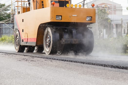 Road roller and asphalt paving machine at construction site