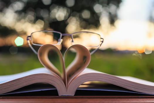 Close up book and glasses on table in sunset time