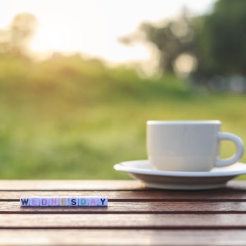 Wednesday written in letter beads and a coffee cup on table