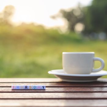 Thursday written in letter beads and a coffee cup on table