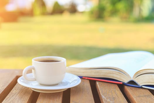 Coffee cup and book on the table in the morning