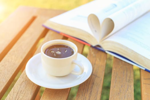 Coffee cup and book on the table in the morning