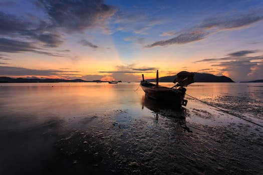 Silhouettes of longtail boat and sunrise in Phuket, Thailand