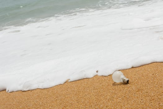 Old light bulb on the beach