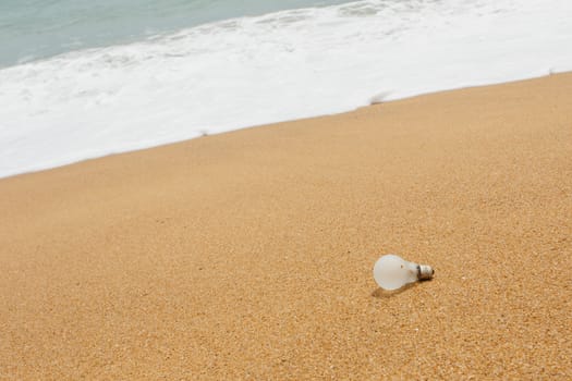 Old light bulb on the beach