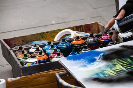 multi colored spray cans are tools of graffiti artists