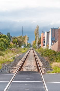 Seemingly endless railroad tracks. 
In an urban scene with beautiful clouds image