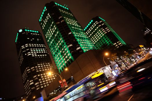 Three tall buildings point up over night traffic in Toronto