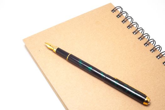 fountain pen and pocketwatch on book
