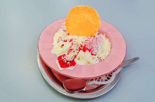 Spaghetti ice cream with waffle on pink plate isolated on white. 