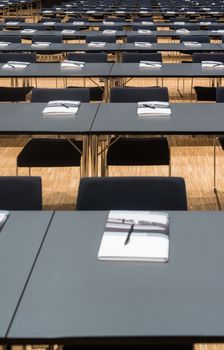 Closeup of a large empty conference room with handouts, papers and pens before meeting