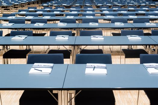 Closeup of a large empty conference room with handouts, papers and pens before meeting