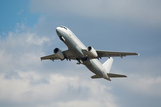 Airplane flying away to the blue sky