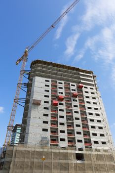 Crane and building construction site against blue sky 