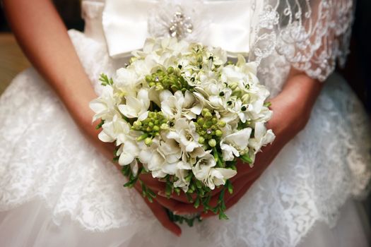 The bride holds a wedding bouquet