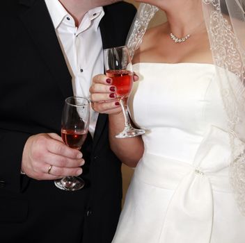 Glasses of champagne in a hand of the groom and bride