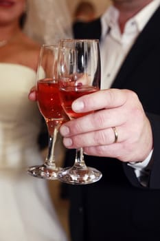 Glasses of champagne in a hand of the groom and bride