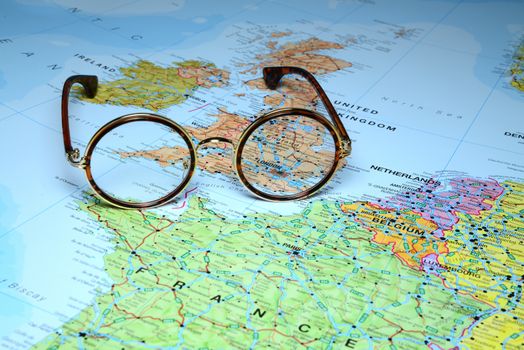 Photo of glasses on a map of europe. Focus on London, Great Britain. May be used as illustration for traveling theme.
