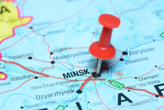 Photo of pinned Minsk on a map of europe. May be used as illustration for traveling theme.