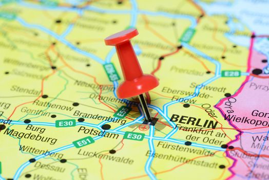 Photo of pinned Berlin on a map of europe. May be used as illustration for traveling theme.