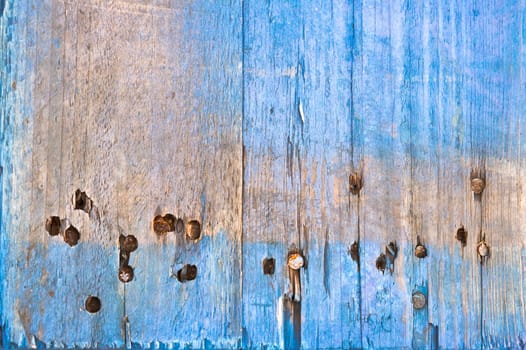 Weathered blue wood with rusty nails as a background