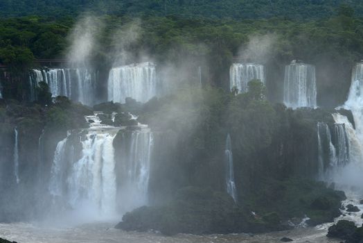 Iguazu waterfall in south americal tropical jungle with a massive flow of water