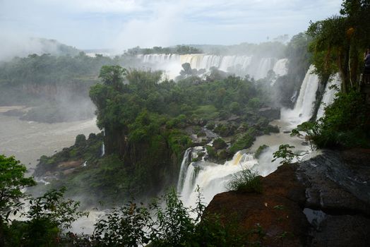 Iguazu waterfall in south americal tropical jungle with a massive flow of water