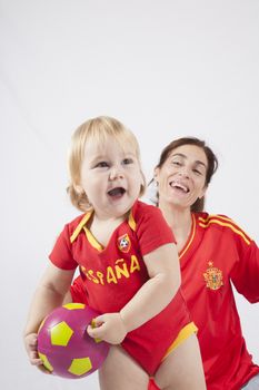 smiling blonde baby sixteen month old and mother with red shirt of Spanish soccer team