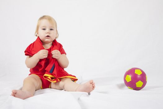 blonde baby sixteen month old with red shirt pink and yellow soccer ball