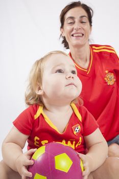 epic look face blonde baby sixteen month old with red shirt of Spanish soccer team and ball