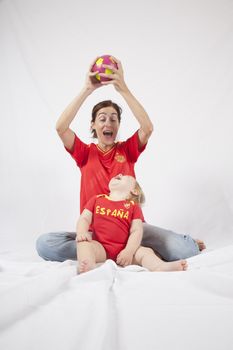 blonde baby sixteen month old and mother with red shirt of Spanish soccer team with ball