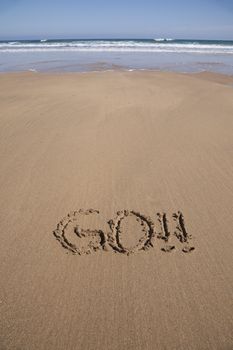 go word written on brown sand ground low tide beach ocean seashore in Spain Europe