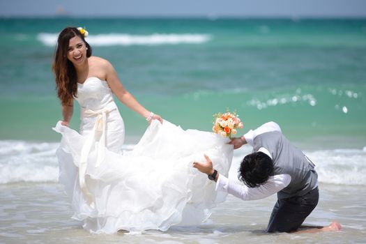 happy just married young asian couple celebrating and have fun at beautiful beach