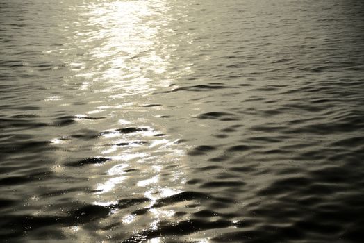 Photo of a water surface with rain drops and sunlight reflection. Taken in Riga, Latvia