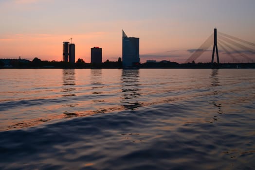 Photo of a sunset at quay and water waves. Taken in Riga.