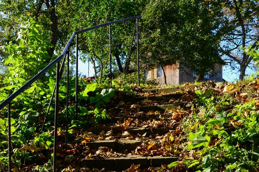 Photo of a stone staircase leading to a house in the forest. Taken in Sigulda.