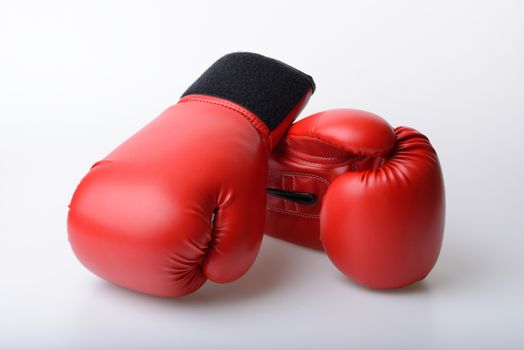 Pair of red leather boxing gloves on white background