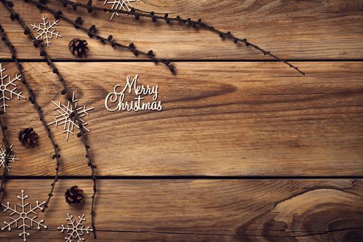 Christmas background with snowflakes and cones on wooden table. Copy space. Top view
