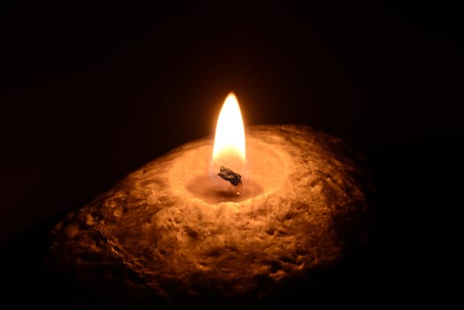 Photo of a burning candle on a black background. Object photography.