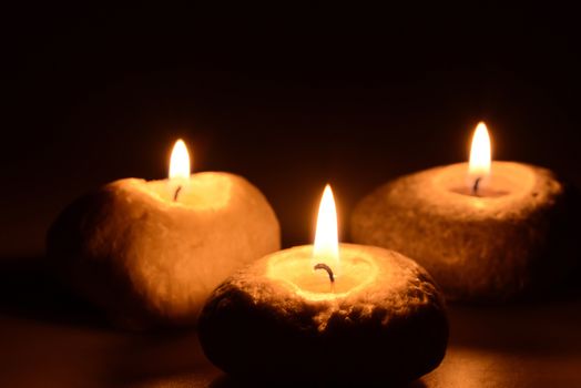 Photo of three candles on a black background. Object photography.