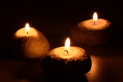 Photo of three candles on a black background. Object photography.