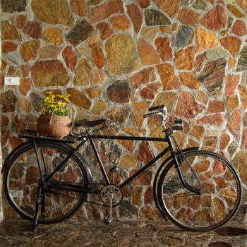 Vintage bicycle leaning against stone brick wall