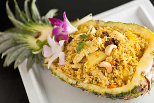 Freshly prepared pineapple fried rice served inside of a pineapple carved like a bowl.