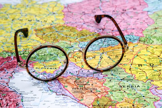 Photo of glasses on a map of europe. Focus on Slovenia. May be used as illustration for traveling theme.