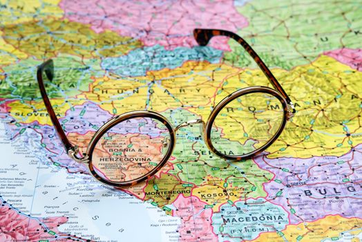 Photo of glasses on a map of europe. Focus on Bosnia and Herzegovina. May be used as illustration for traveling theme.