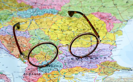 Photo of glasses on a map of europe. Focus on Kosovo. May be used as illustration for traveling theme.