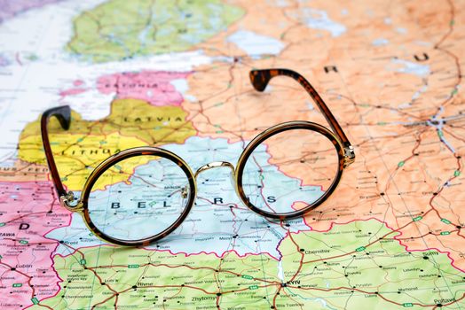 Photo of glasses on a map of europe. Focus on Belarus. May be used as illustration for traveling theme.