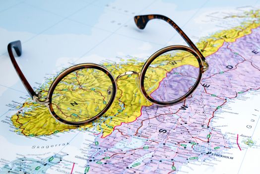 Photo of glasses on a map of europe. Focus on Norway. May be used as illustration for traveling theme.