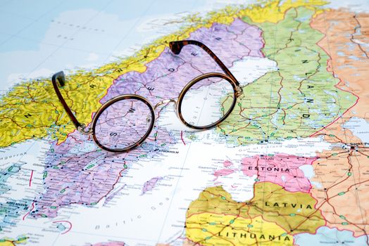 Photo of glasses on a map of europe. Focus on Sweden. May be used as illustration for traveling theme.